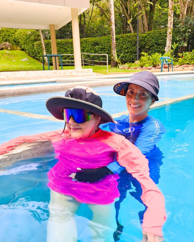 Fisioterapeuta de AUA FIT asistiendo a una paciente mayor en una sesión de mantenimiento y movilidad del Plan Activa de hidroterapia en Cali.