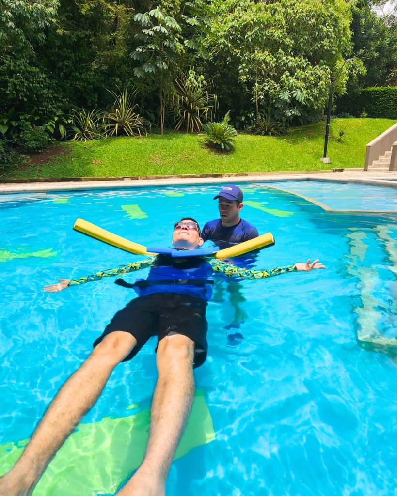 Hombre flotando en estado de relajación total durante una sesión de hidroterapia del Plan Plenitud de AUA FIT en Cali.