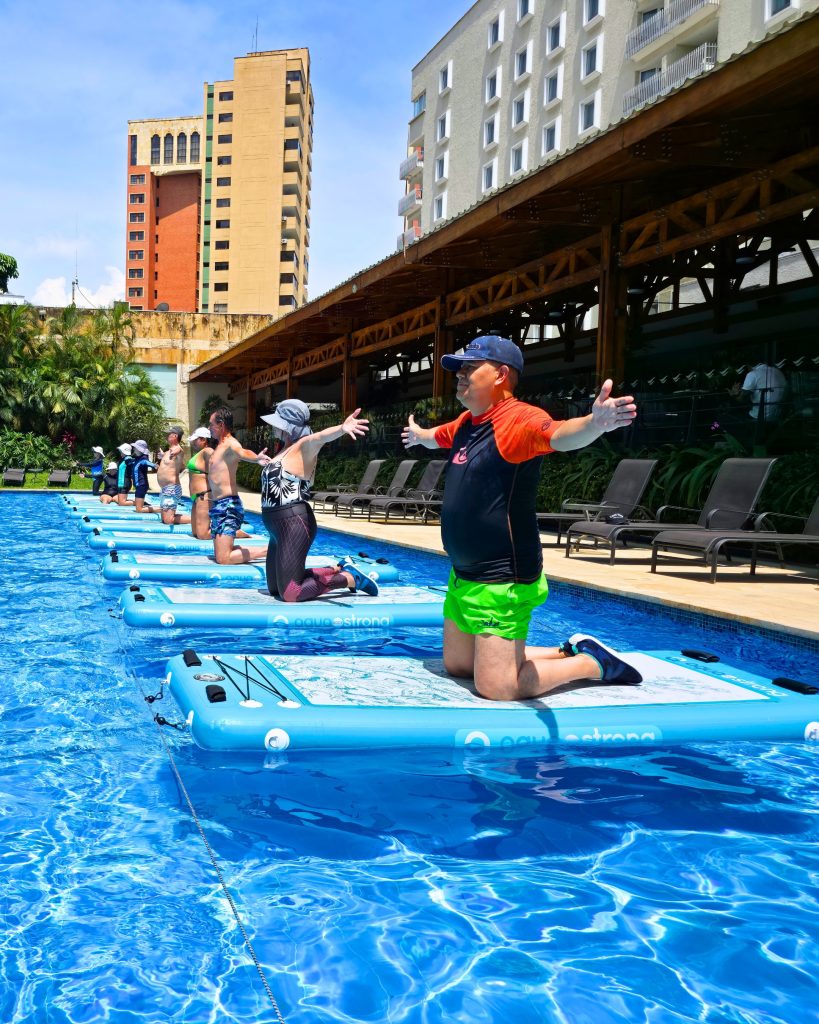 Clase de AquaBOARD Pilates en Cali con AUA FIT. Alumnos practicando equilibrio y fortalecimiento del core en tablas flotantes.