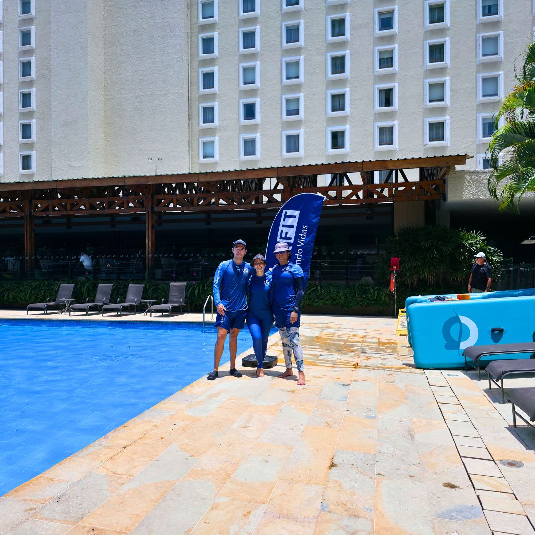 Equipo de fisioterapeutas fundadores de AUA FIT posando orgullosos frente a su sede premium en la piscina del Hotel Intercontinental Cali. Un hito de evolución en la historia de la marca deportiva.